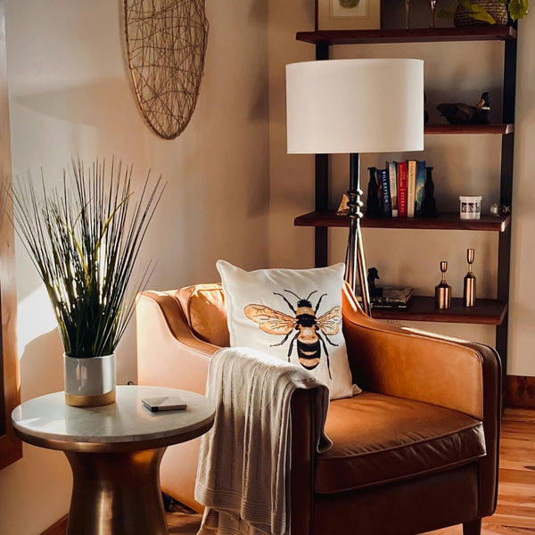 Cozy living room with brown armchair, side table, and bookshelf.