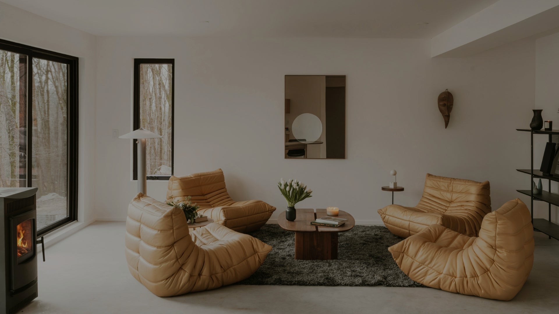 Modern living room with beige bean bags, a coffee table, and a fireplace.