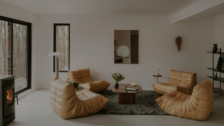 Modern living room with beige bean bags, a coffee table, and a fireplace.